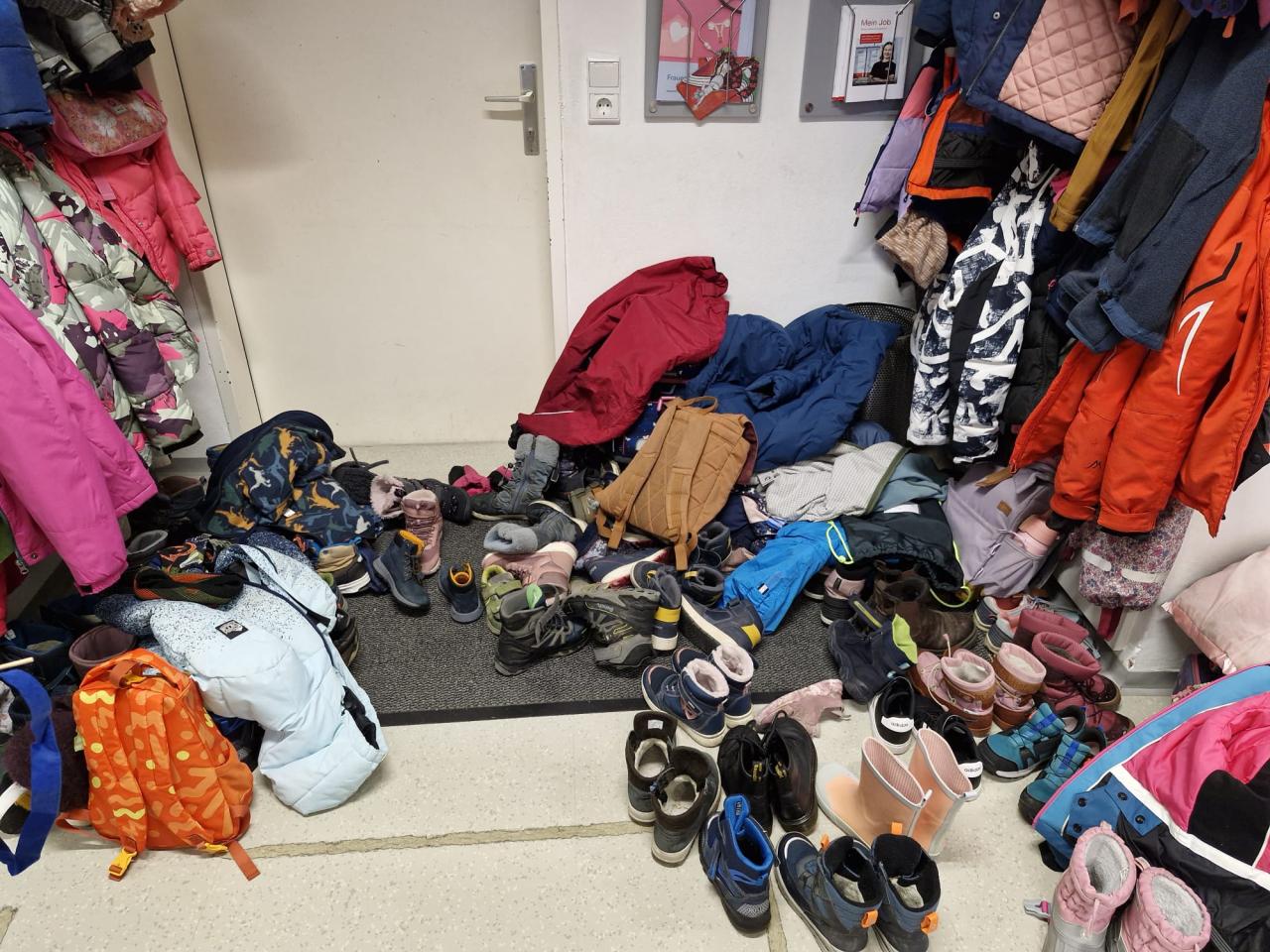 Bücherei-Garderobe voll mit Schuhen und Mänteln